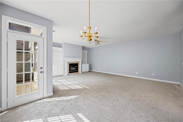 unfurnished living room with carpet, baseboards, radiator heating unit, a textured ceiling, and a chandelier