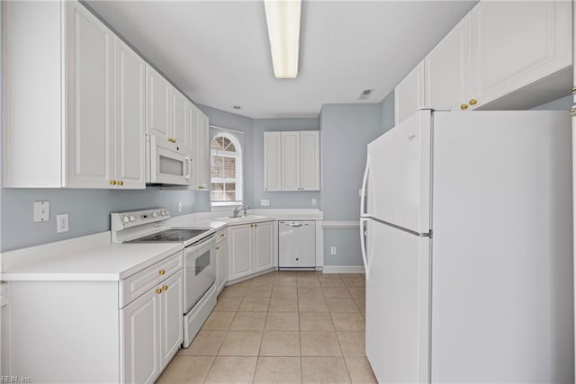 kitchen with light tile patterned floors, white cabinets, white appliances, and light countertops