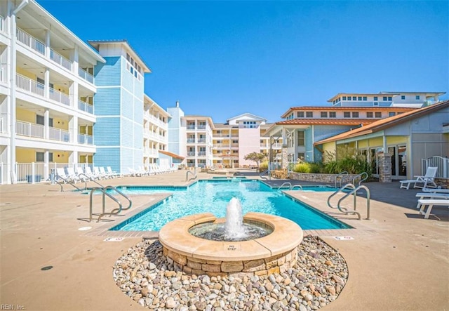community pool featuring fence and a patio area