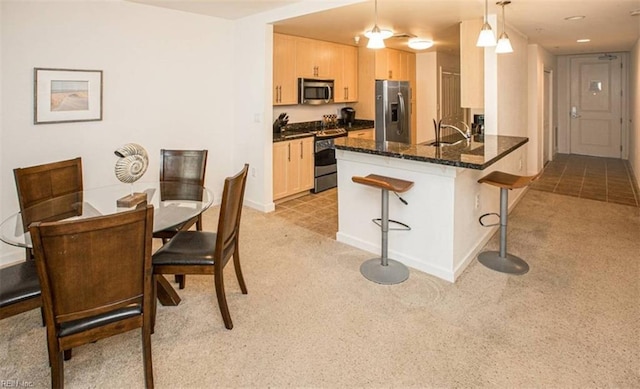 kitchen featuring a sink, stainless steel appliances, light colored carpet, and light brown cabinets