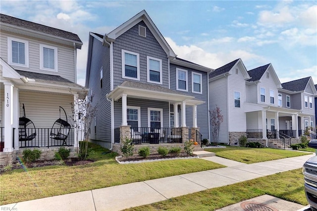 view of front of property featuring a residential view, covered porch, and a front yard