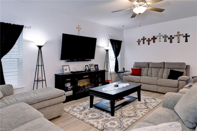 living area with a ceiling fan and light wood-type flooring
