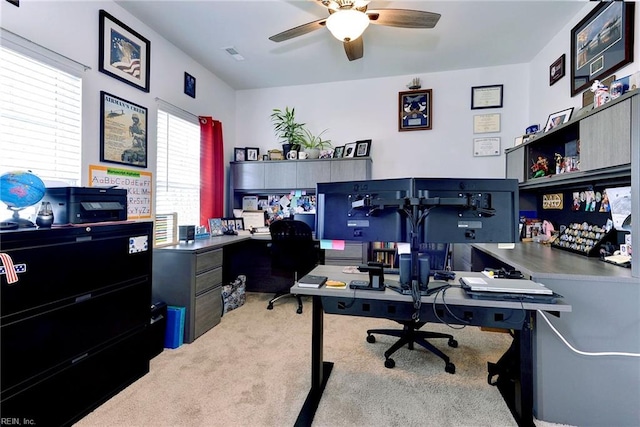 office space with visible vents, carpet, and ceiling fan