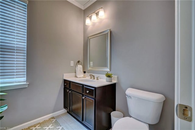 bathroom featuring tile patterned floors, toilet, vanity, baseboards, and ornamental molding