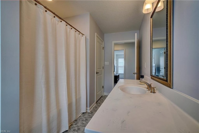 full bathroom with a textured ceiling and vanity