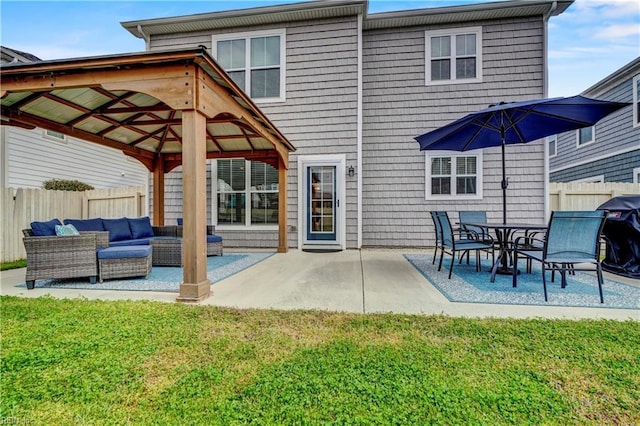 rear view of property with an outdoor hangout area, fence, a gazebo, a yard, and a patio area