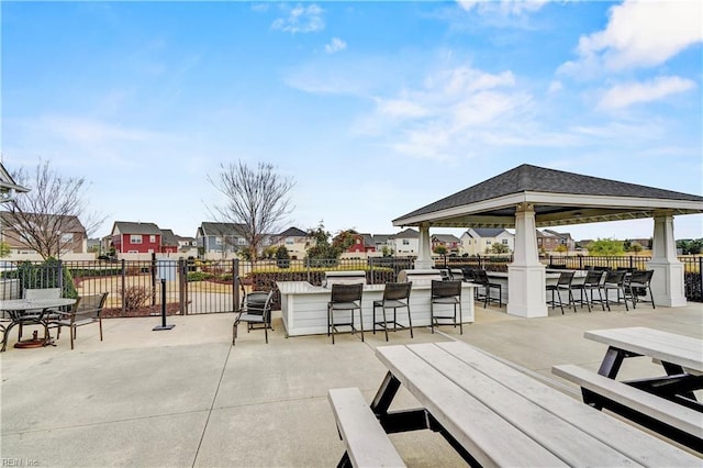 view of patio / terrace featuring a residential view, outdoor dry bar, and fence
