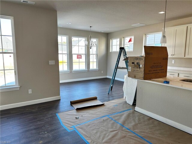 interior space with dark wood finished floors, visible vents, and baseboards