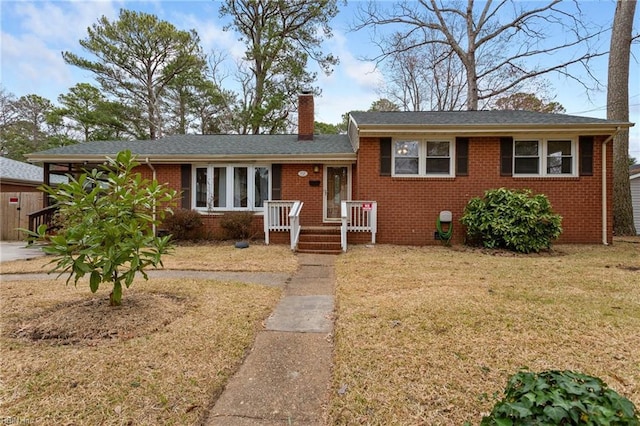 split level home featuring a front lawn, brick siding, and a chimney