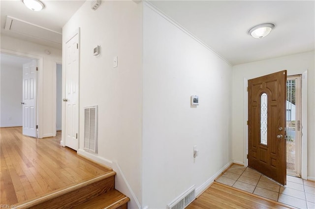 foyer entrance featuring baseboards, visible vents, and light wood finished floors