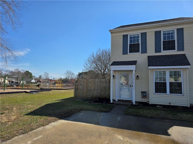 view of front of property with a shingled roof, a playground, a front lawn, and fence