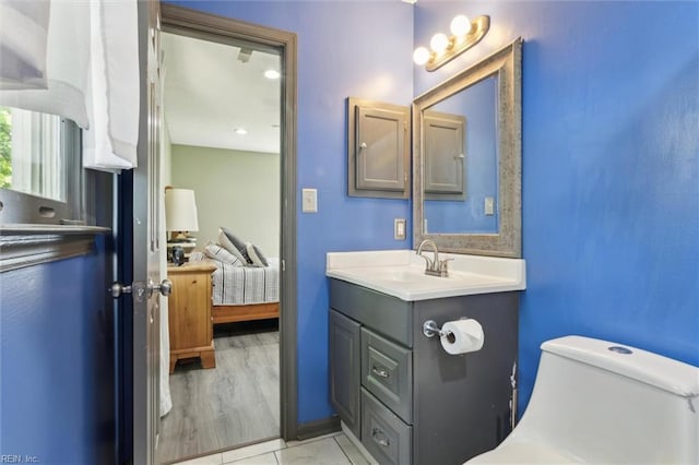 bathroom with toilet, ensuite bathroom, and vanity