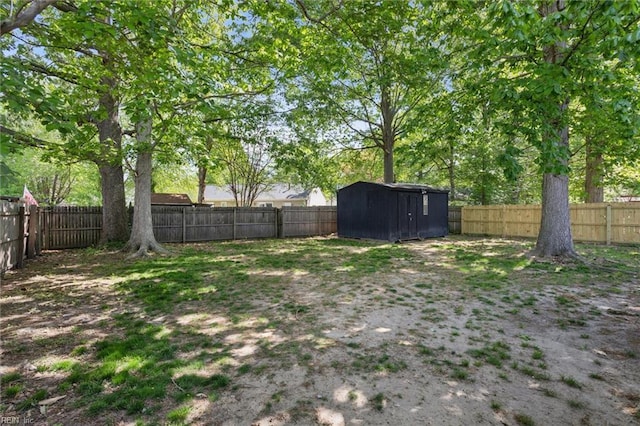 view of yard featuring an outdoor structure, a fenced backyard, and a shed