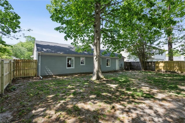 rear view of house featuring a fenced backyard