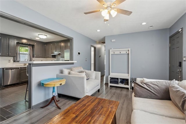 living room with recessed lighting, a ceiling fan, dark wood finished floors, and visible vents
