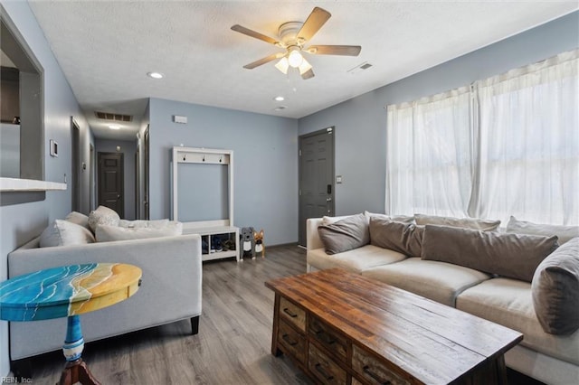 living area featuring a ceiling fan, recessed lighting, wood finished floors, and visible vents