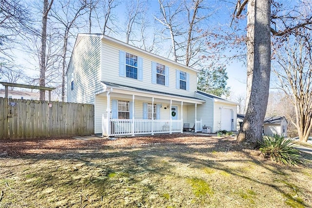 view of front of house featuring a garage, a porch, and fence