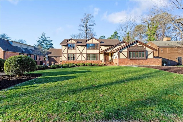 rear view of house featuring a lawn, brick siding, and stucco siding