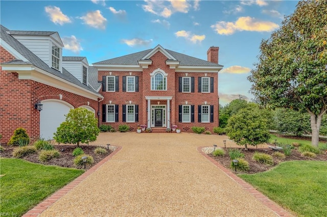 100 Eaglescliffe, Williamsburg, VA 23188 - view of front facade featuring a chimney, an attached garage, a front yard, and brick siding