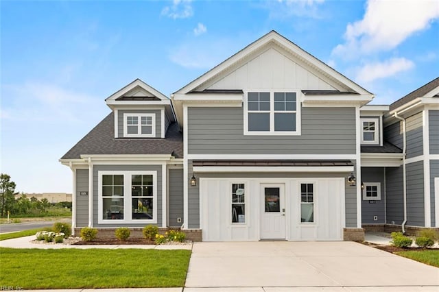 craftsman house featuring a front lawn, board and batten siding, driveway, and a shingled roof