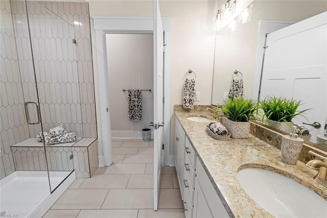bathroom with tile patterned flooring, a shower stall, double vanity, and a sink