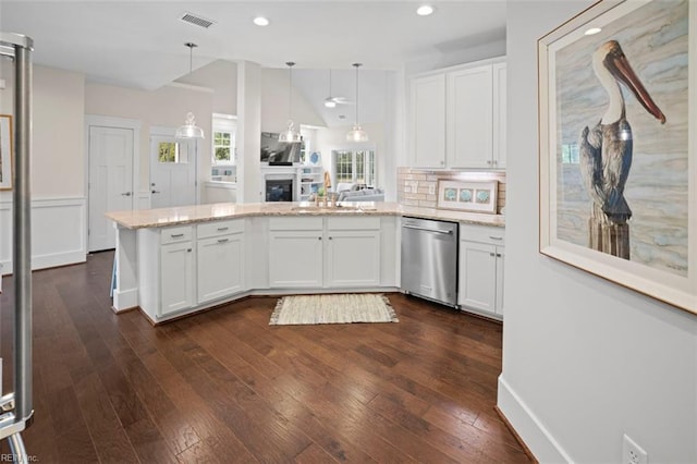 kitchen featuring visible vents, a peninsula, vaulted ceiling, white cabinets, and stainless steel dishwasher
