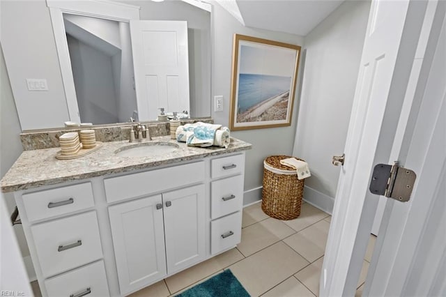 bathroom with tile patterned flooring, vanity, and baseboards