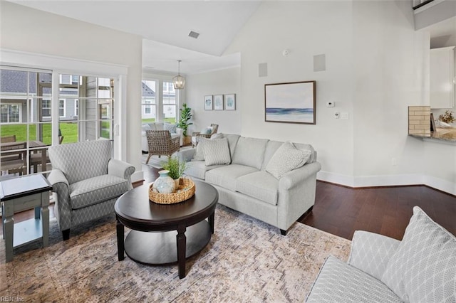 living room with visible vents, baseboards, high vaulted ceiling, and wood finished floors