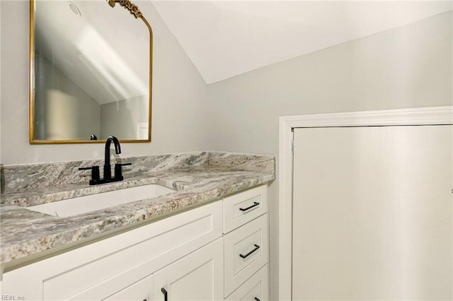 bathroom featuring lofted ceiling and vanity