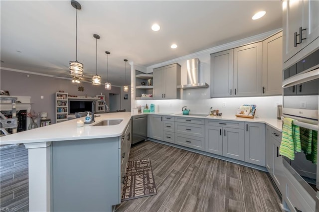 kitchen with gray cabinets, a sink, stainless steel appliances, wall chimney exhaust hood, and ceiling fan