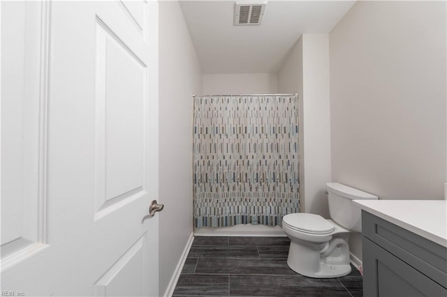 bathroom featuring visible vents, toilet, a shower with shower curtain, wood finished floors, and vanity