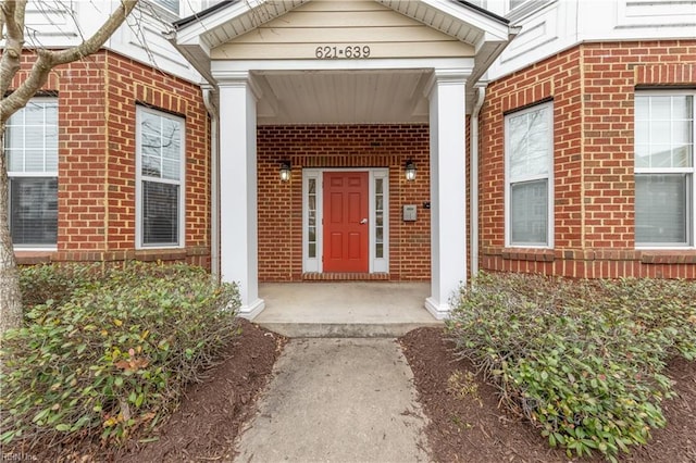 property entrance featuring brick siding