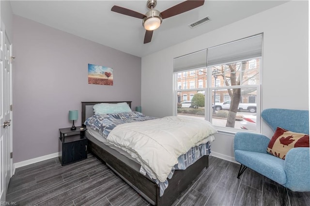 bedroom with a ceiling fan, dark wood-type flooring, baseboards, and visible vents