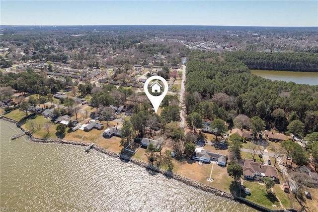 birds eye view of property featuring a forest view and a water view