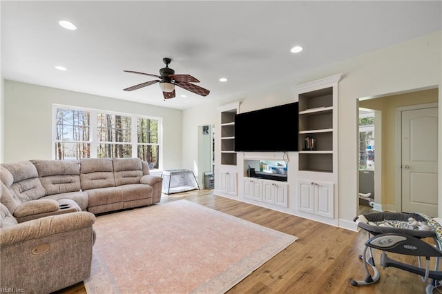 living room with a ceiling fan, recessed lighting, baseboards, and light wood-type flooring