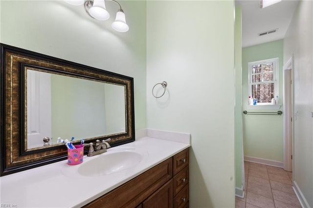 bathroom with tile patterned flooring, vanity, baseboards, and visible vents