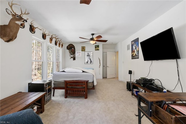 bedroom featuring light colored carpet, visible vents, and a ceiling fan