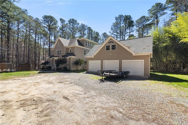 view of front facade with an outbuilding, driveway, and a garage