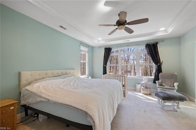 bedroom featuring multiple windows, a tray ceiling, baseboards, and crown molding