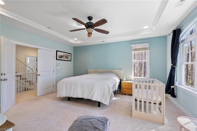 bedroom with multiple windows, crown molding, and a raised ceiling