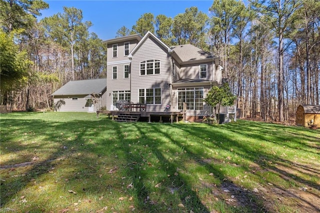 rear view of property with an outdoor structure, a storage unit, a yard, and a wooden deck