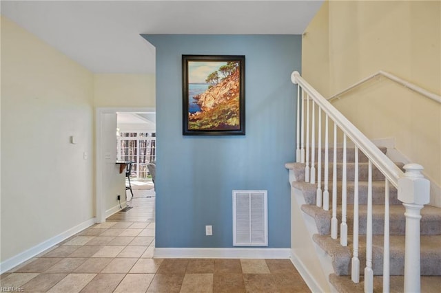 stairs with baseboards, visible vents, and tile patterned floors