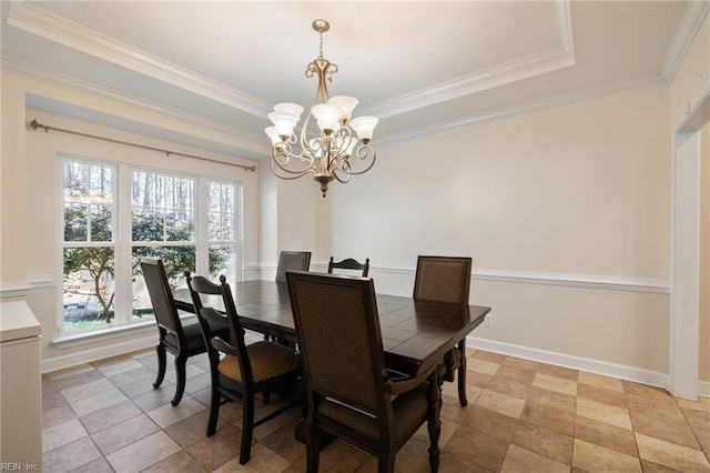 dining space with baseboards, ornamental molding, a notable chandelier, and a raised ceiling