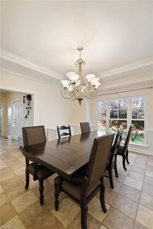 dining area with baseboards, crown molding, and an inviting chandelier