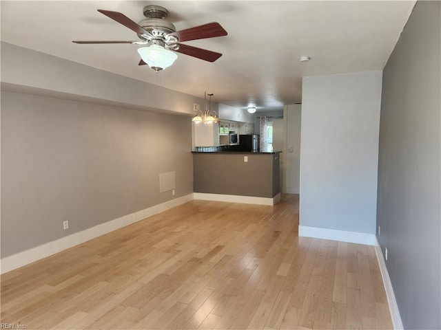 unfurnished living room with ceiling fan, baseboards, and light wood-style floors