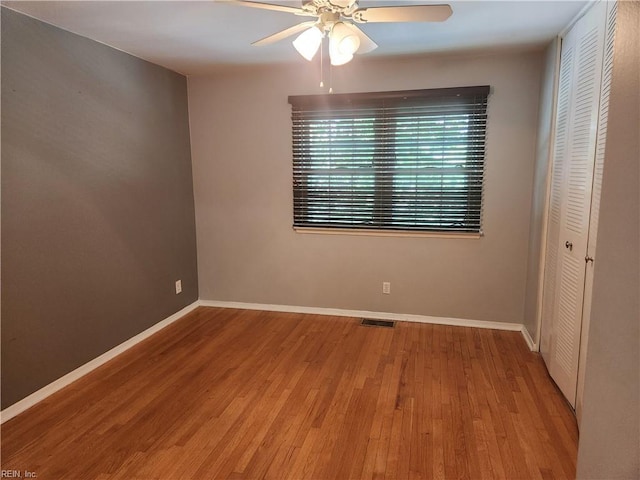 unfurnished bedroom with a closet, wood finished floors, and baseboards