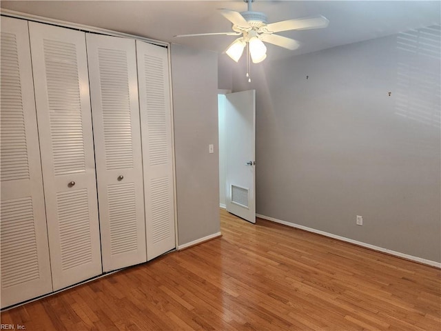 unfurnished bedroom with a closet, light wood-style flooring, baseboards, and ceiling fan
