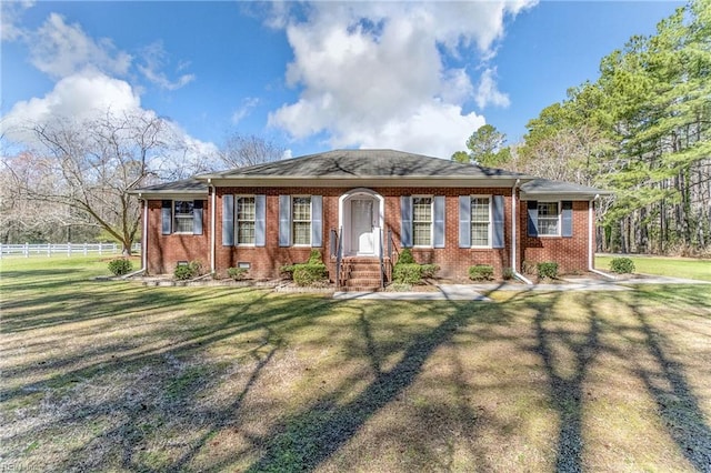view of front of home featuring brick siding, fence, and a front yard
