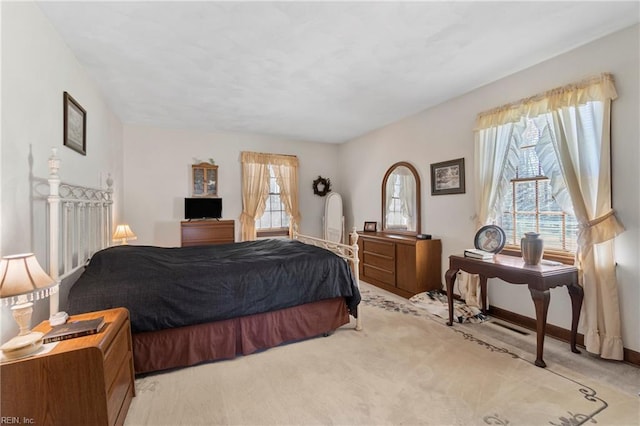 bedroom featuring baseboards and light colored carpet