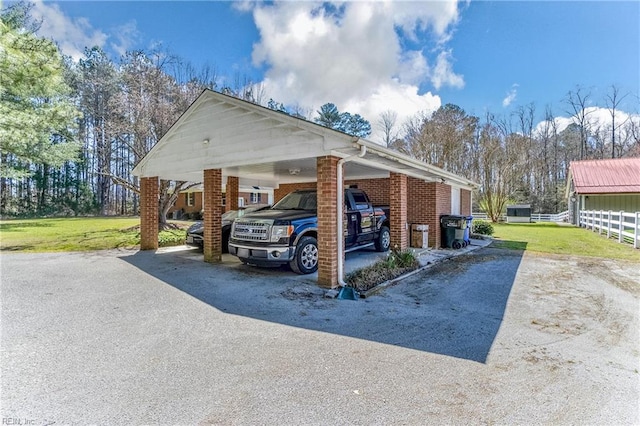 view of vehicle parking featuring driveway and a carport